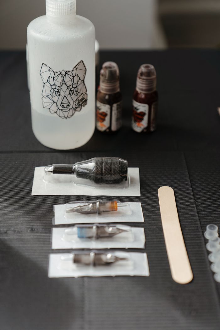 services-03 Close-up of tattoo needles, ink bottles, and equipment at a tattoo studio.